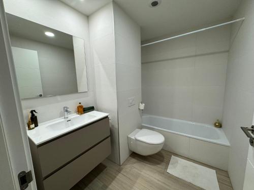 Un baño con lavabo, inodoro y bañera. en San Fermín centro, en Pamplona