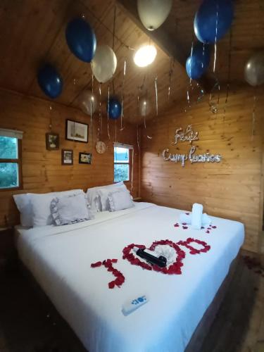 a bed with balloons and a sign that says happy birthday at Glamping Entre Nopales, Villa de Leyva in Sáchica