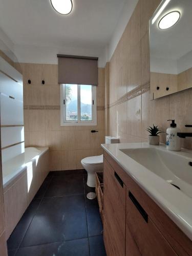 a bathroom with a tub and a sink and a toilet at House with a tropical garden in Adeje