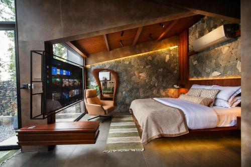 Un dormitorio con una cama grande y una pared de piedra. en ESCAPE Hotels & Resorts, en Nathia Gali