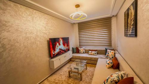 a living room with a couch and a tv at Deluxe apartment - Banana Beach in Aourir