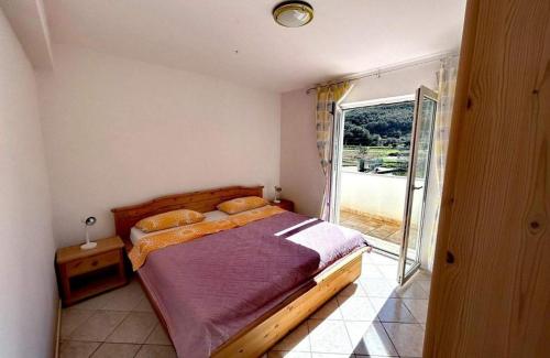 ein Schlafzimmer mit einem Bett und einer Glasschiebetür in der Unterkunft Holiday house with a parking space Supetarska Draga - Donja, Rab - 24284 in Rab