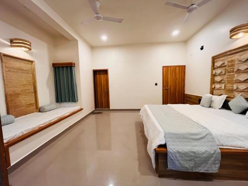 a bedroom with a bed and two windows at Brook Ville in Sasan Gir
