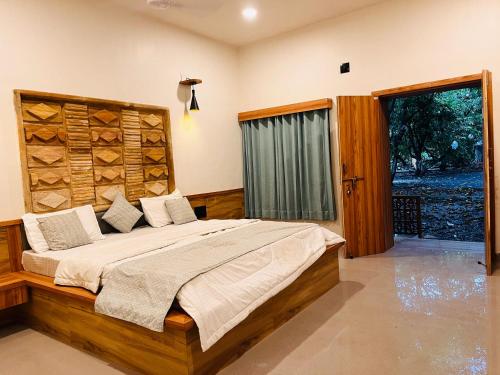 a bedroom with a large bed and a window at Brook Ville in Sasan Gir