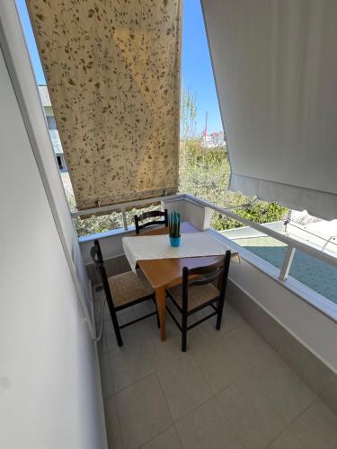 a table and chairs in a room with a window at Vila Reni Risi in Ksamil