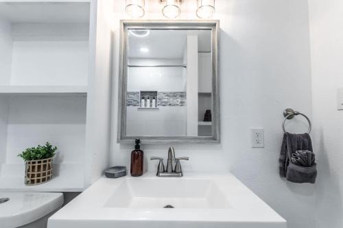 Un baño blanco con lavabo y espejo. en Serenity Suites C, en Corpus Christi