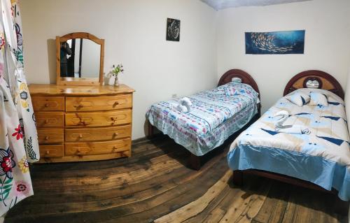 una camera con due letti, un comò e uno specchio di Departamento Completo Confortable a Latacunga