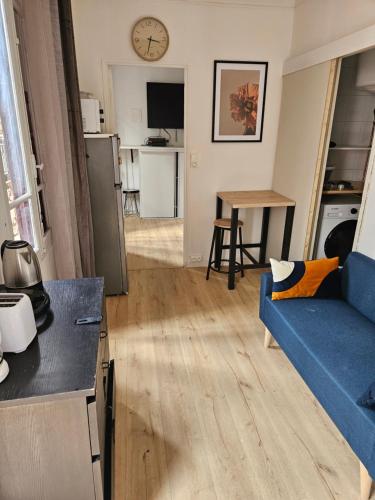 un salon avec un canapé bleu et une table dans l'établissement Cozy ivry, à Ivry-sur-Seine