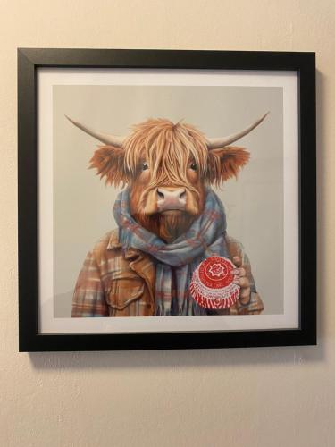 a painting of a cow wearing a scarf at Carnegie Lodgings, Tain in Tain