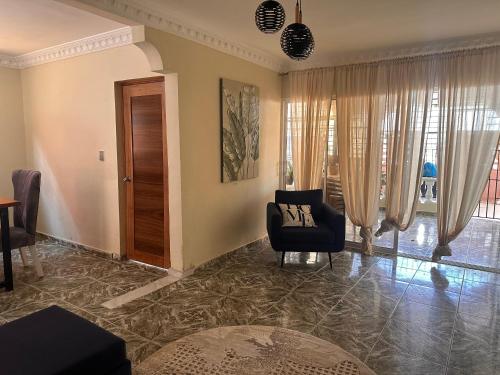 a living room with a chair and a table at Villa Amarilis in Boca Chica