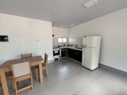 a kitchen with a table and a refrigerator at Steves House Flat Hotel in Puerto Iguazú