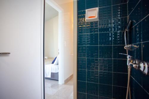 a bathroom with a shower with blue tiles at Ionian Blue Maisonettes in Benitses