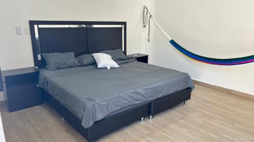 1 dormitorio con 1 cama grande con marco negro en Casita azul progreso, en Progreso