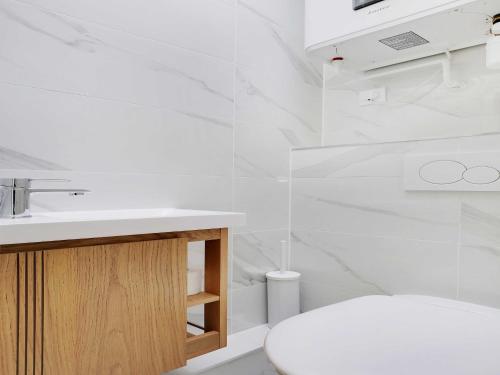 une salle de bain blanche avec des toilettes et un lavabo dans l'établissement Cosy duplex - 2BDR 4P - Levallois So Ouest, à Levallois-Perret