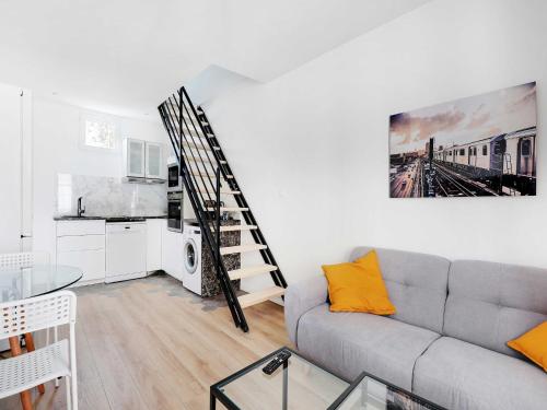 - un salon avec un canapé gris et un escalier dans l'établissement Cosy duplex - 2BDR 4P - Levallois So Ouest, à Levallois-Perret