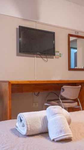 a bedroom with a bed with a television on the wall at Altair Hotel in San Clemente del Tuyú