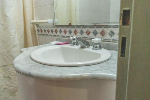 a bathroom with a white sink and a mirror at Altair Hotel in San Clemente del Tuyú