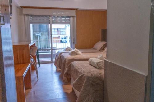 a hotel room with two beds and a balcony at Altair Hotel in San Clemente del Tuyú