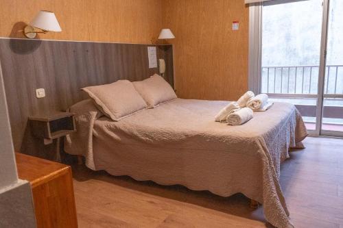 a bedroom with a bed with towels on it at Altair Hotel in San Clemente del Tuyú