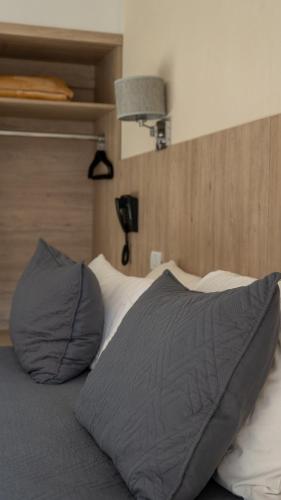 a bed with a gray pillow on top of it at Altair Hotel in San Clemente del Tuyú