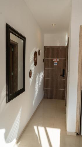 a hallway with a mirror on the wall and a door at Altair Hotel in San Clemente del Tuyú