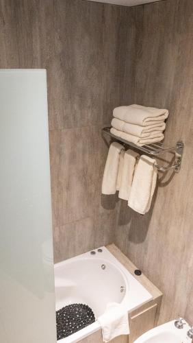 a bathroom with a sink and a tub and towels at Altair Hotel in San Clemente del Tuyú