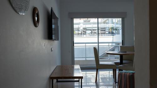 a room with a table and chairs and a window at Altair Hotel in San Clemente del Tuyú