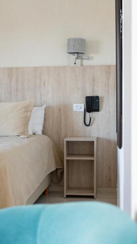 a bedroom with a bed and a phone on the wall at Altair Hotel in San Clemente del Tuyú