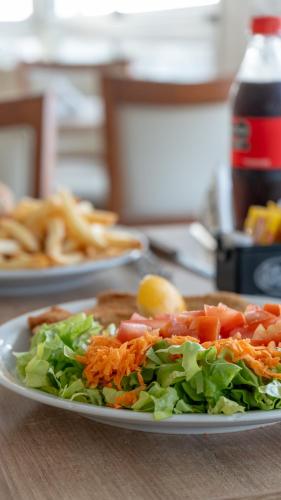 a plate of food with a salad on a table at Altair Hotel in San Clemente del Tuyú
