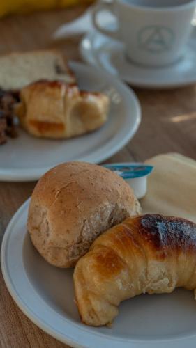 two rolls and croissants on plates on a table at Altair Hotel in San Clemente del Tuyú