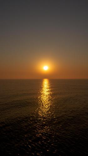 a sunset over the ocean with the sun setting at Altair Hotel in San Clemente del Tuyú