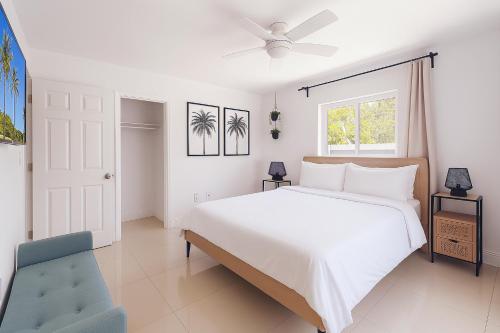 a white bedroom with a large bed and a window at Central Miami Oasis, Near Brickell, Grove & Little Havana in Miami