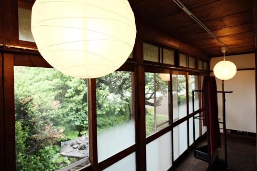 a room with a large window with a large lamp at 古民家の宿 奈味 in Saitama