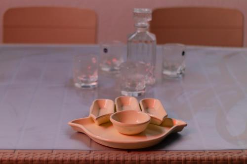 a plate on a table with glasses and a bottle at Le Rooftop Apparte - Barbecue, Grande Terrasse in Nabeul