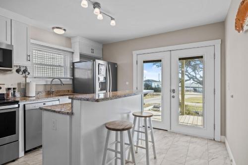 a kitchen with a counter and two bar stools at Mi Faro Unit A Duplex in Harkers Island