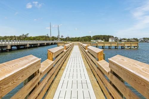 a wooden dock with benches on the water at Mi Faro Unit A Duplex in Harkers Island