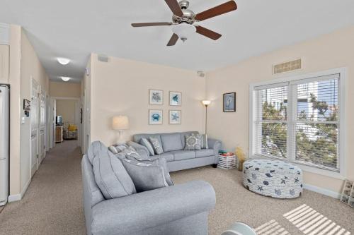 a living room with a couch and a ceiling fan at One More Drift home in Atlantic Beach