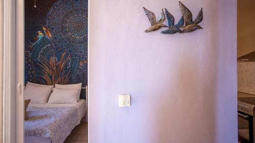 a room with a bed and two birds on the wall at Ionian Kaizer Boutique in Achílleion