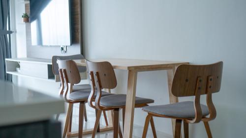 three chairs around a wooden table in a kitchen at Mid Vally Southkey JB, 2BR, WIFI, 7 mins to CIQ , 5-7pax in Johor Bahru