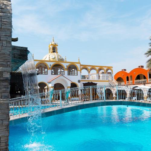 a swimming pool with a fountain in front of a building at Macacona Hacienda Hotel in Ica