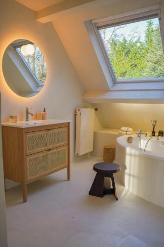 La salle de bains est pourvue d'un lavabo, d'une baignoire et d'une fenêtre. dans l'établissement Country house in foresr of Rambouillet, à Auffargis