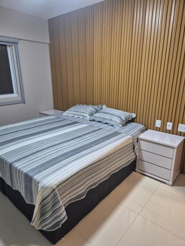 a bedroom with a large bed with a wooden wall at Apartamento Confortável e Espaçoso em Condomínio Familiar, 2 Quartos com 1 suíte e Lazer de Clube in Belém