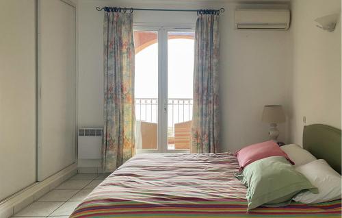 a bedroom with a bed and a large window at Lovely Apartment In Algajola in Algajola
