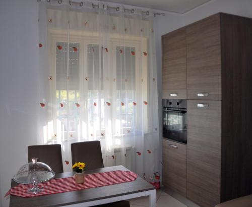 a kitchen with a table and a white curtain at B&B Villa Angelica in Mili Marina
