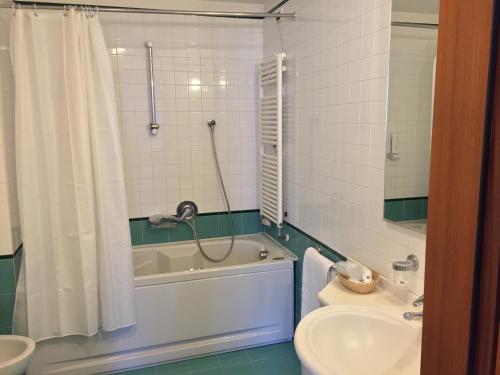 a bathroom with a tub and a toilet and a sink at Hotel Le Roi in Varazze
