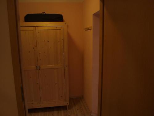 a closet with a wooden cabinet in a room at Apartments Viktoria Klinovec in Kovářská