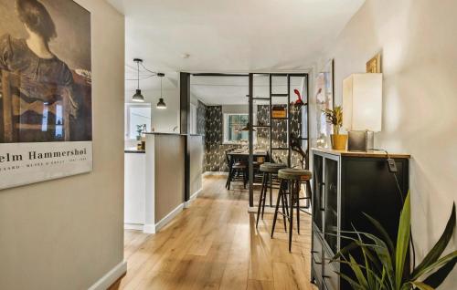 a kitchen and living room with a bar and stools at 3 Bedroom Awesome Home In Faaborg in Fåborg