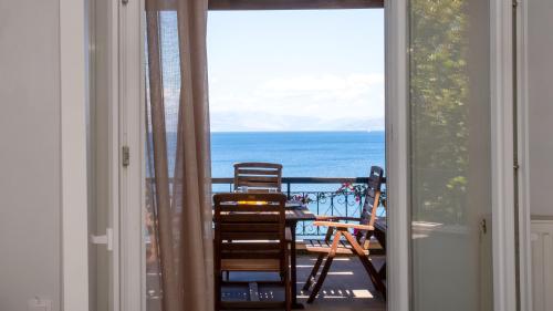 a room with a balcony with a table and chairs at Ionian Kaizer Boutique in Achílleion