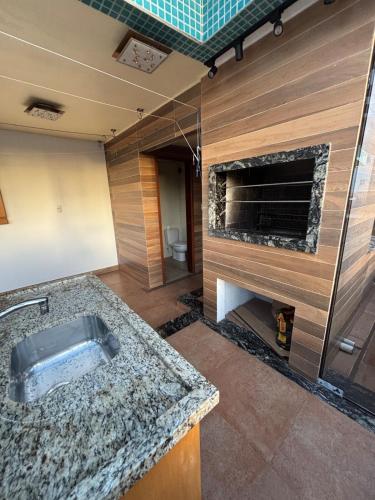 a bathroom with a sink and a fireplace at Apartamento Duplex Rio grande centro 250 m privado dois quartos in Rio Grande