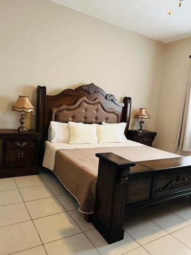 a bedroom with a large bed with two night stands at Hostería Casa Marquez in León